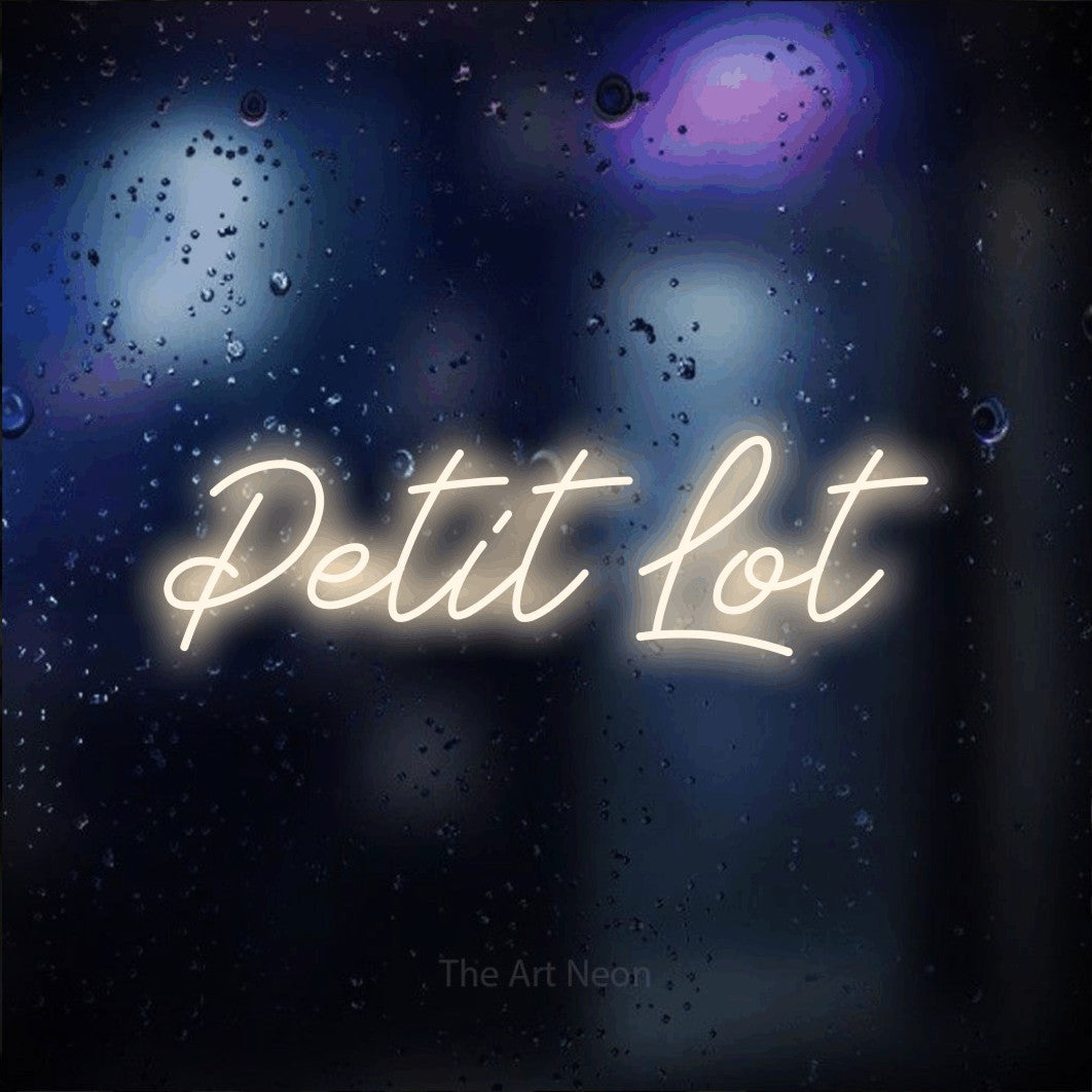 Néon LED « Petit lot » en blanc chaud, en lettrage cursif, mis en scène sur une vitre aux reflets bleus et violets, pour un café.