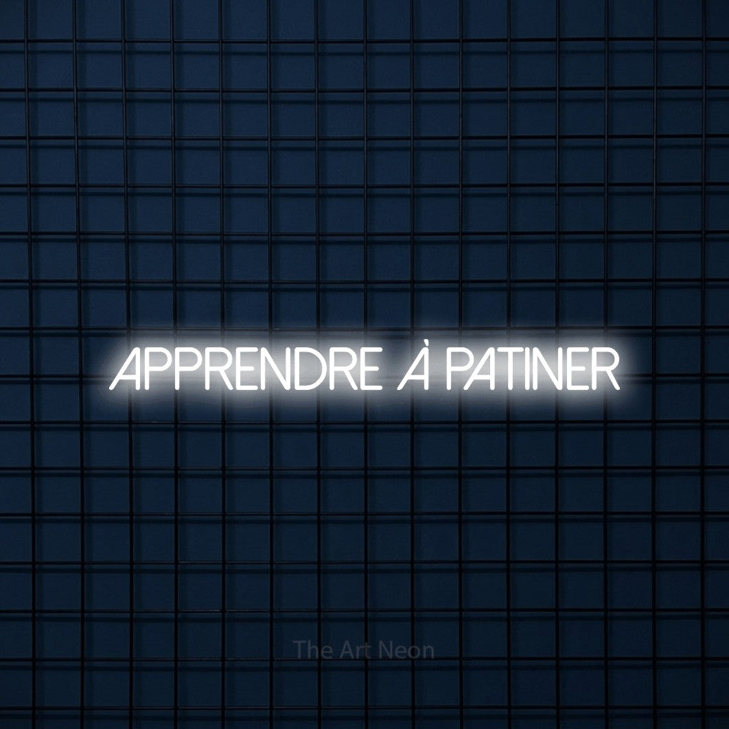 “Apprendre à patiner” LED neon sign in cool white, with thin sans-serif lettering, shown against a dark blue grid.