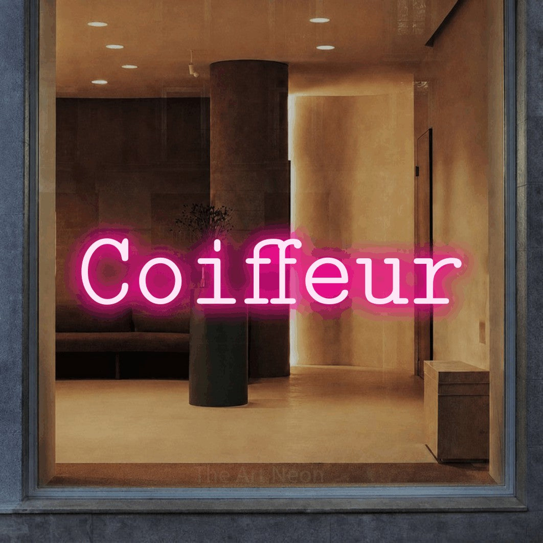 “Coiffeur” LED neon sign in hot pink, with typewriter-style lettering, shown against a warm-toned interior.