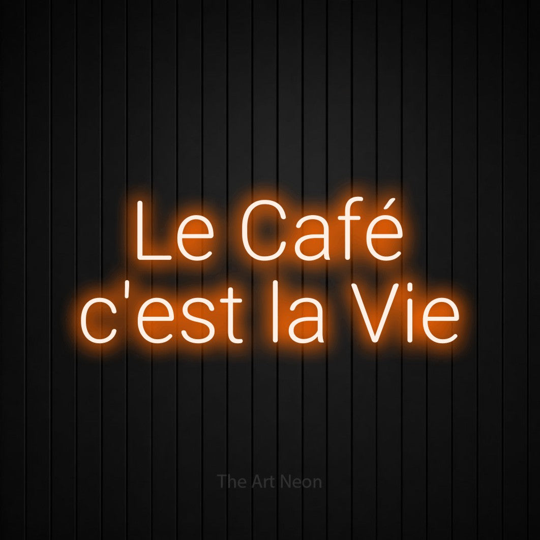 Décoration murale en néon LED « Le café c'est la vie » sur deux lignes en orange, en lettres sans empattement arrondies, installée sur un mur de lattes verticales noires, pour une cuisine.