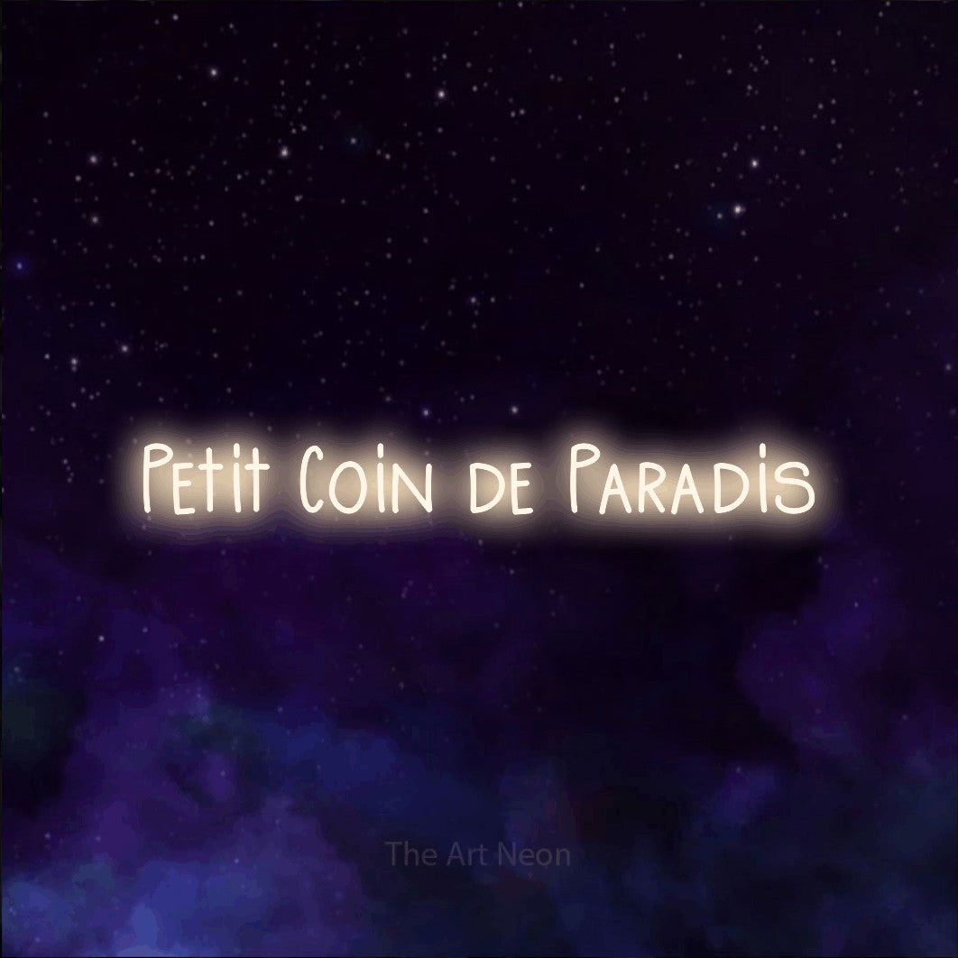 “Petit coin de paradis” LED neon sign in warm white, with narrow hand-drawn lettering, shown against a purple galaxy backdrop.