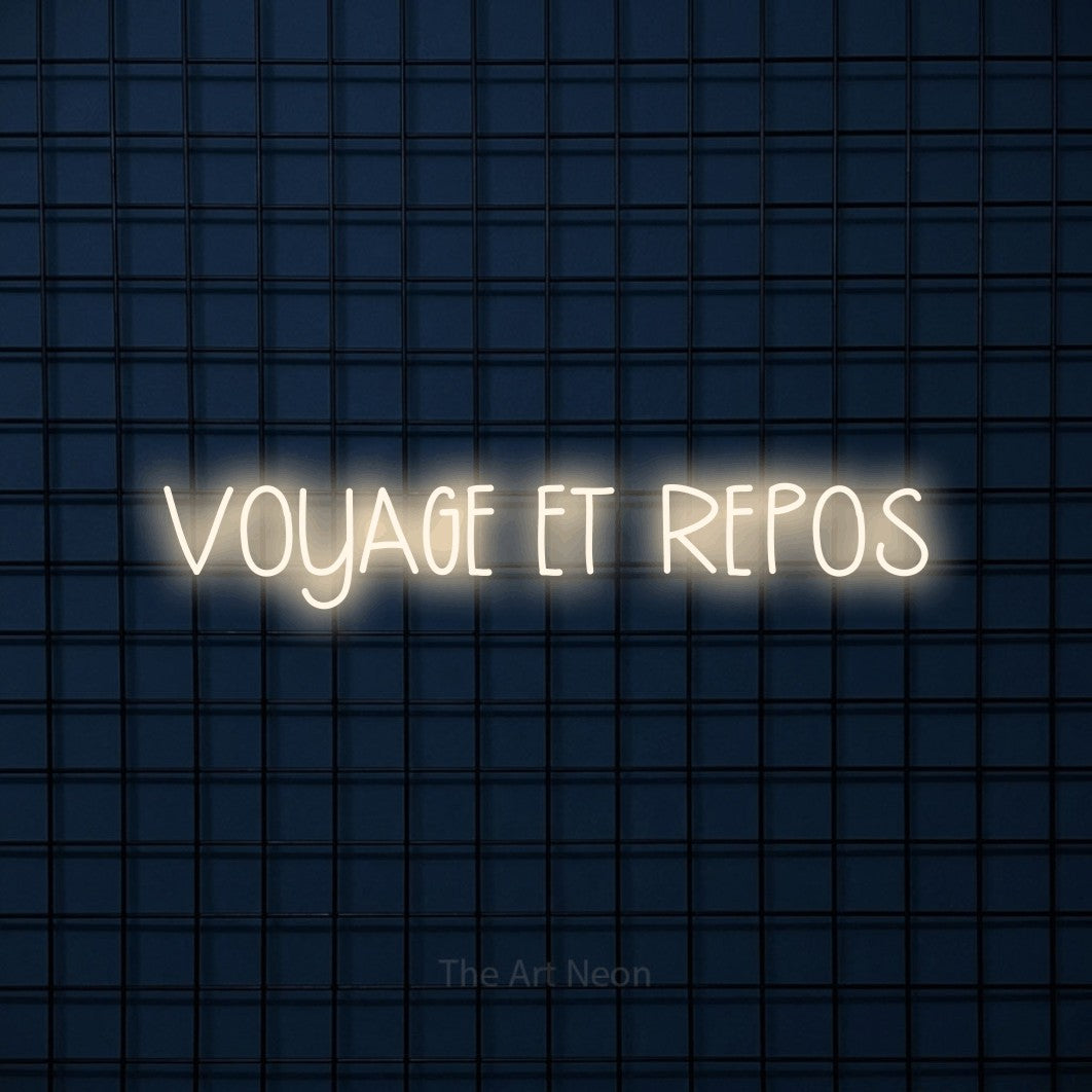“Voyage et repos” LED neon sign in warm white, with narrow hand-drawn lettering, shown against a dark blue grid.