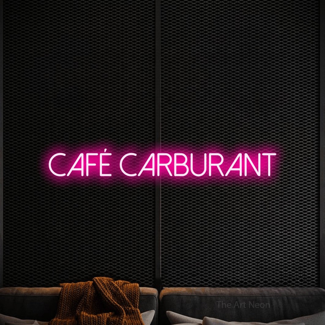 “Café carburant” LED neon sign in hot pink, with thin sans-serif lettering, shown against a modern dark-toned seating area.