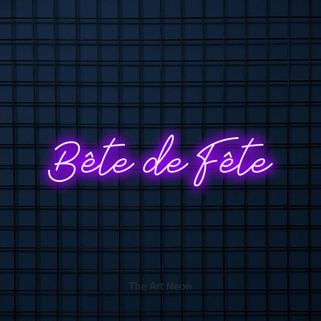 “Bête de fête” LED neon sign in purple, with cursive lettering, shown against a dark blue grid.
