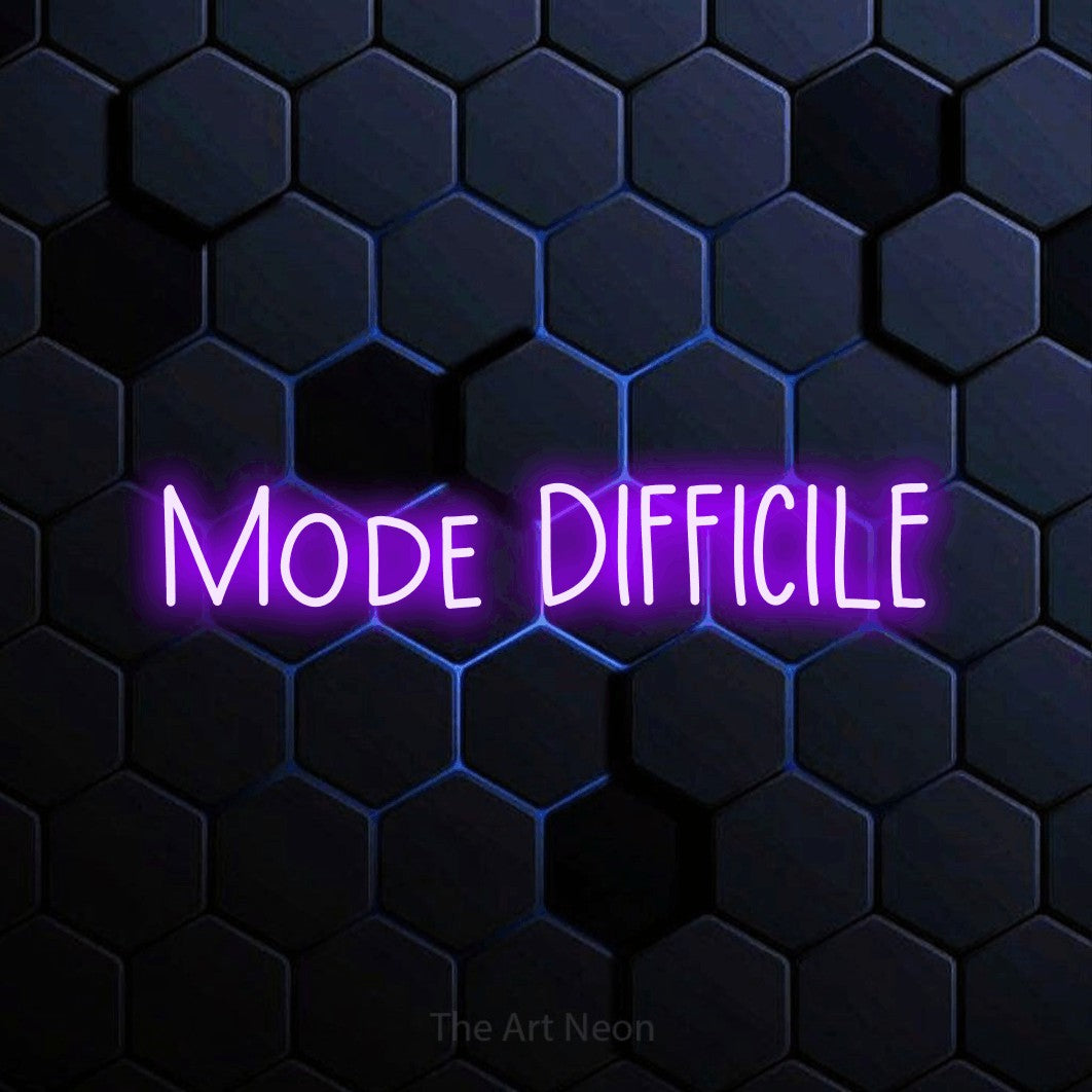 “Mode difficile” LED neon sign in purple, with narrow hand-drawn lettering, shown against a dark blue honeycomb pattern.