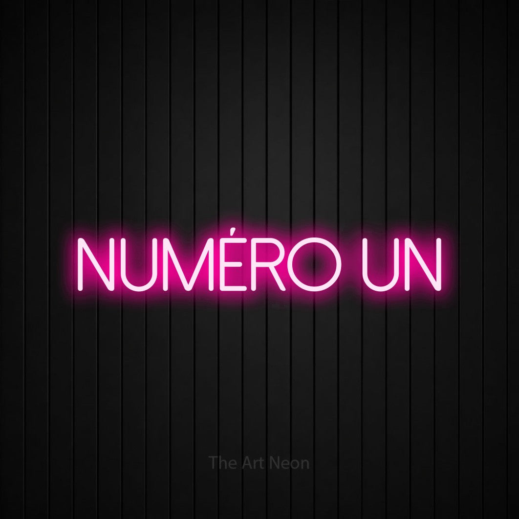 “Numéro un” LED neon sign in hot pink, with thin sans-serif lettering, shown against black vertical wall slats.