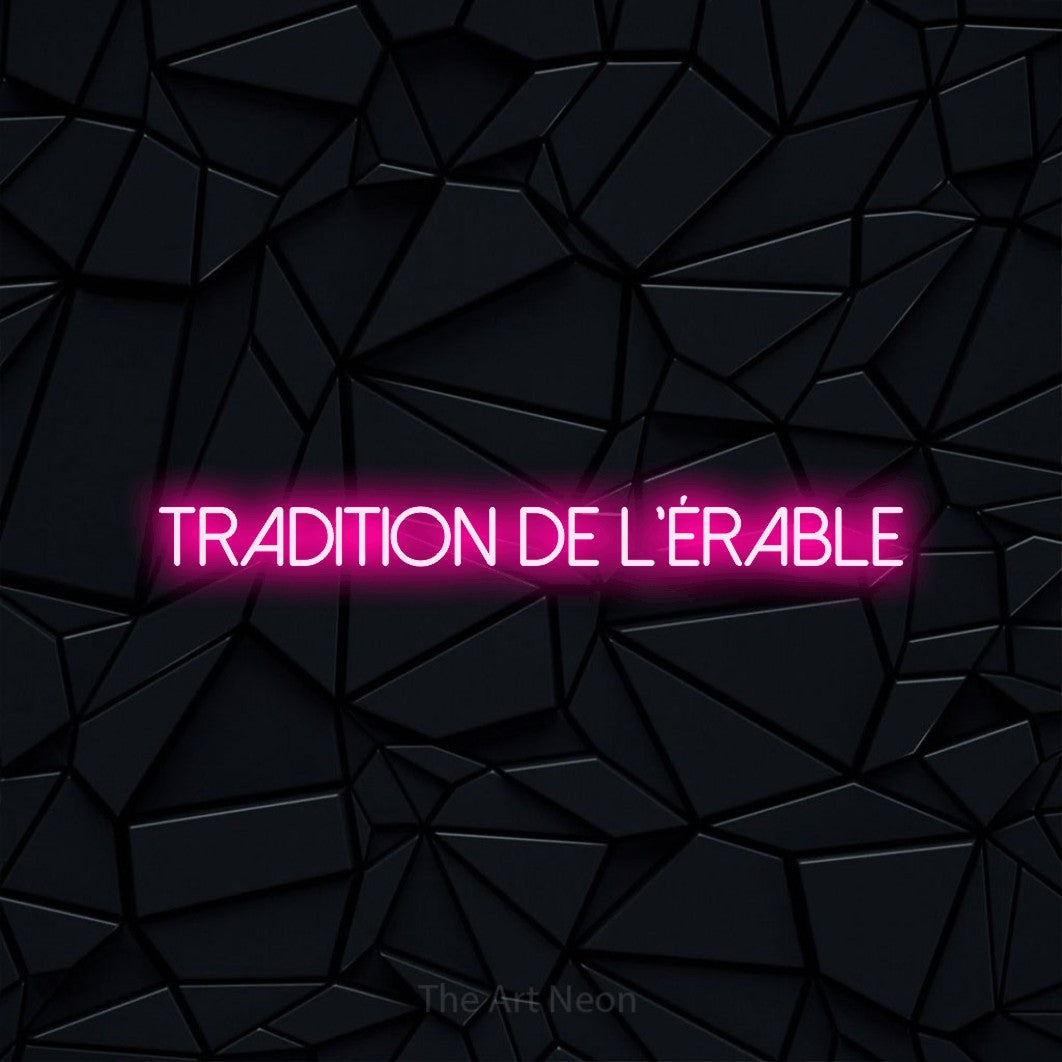 “Tradition de l'érable” LED neon sign in hot pink, with thin sans-serif lettering, shown against a black polygonal surface.