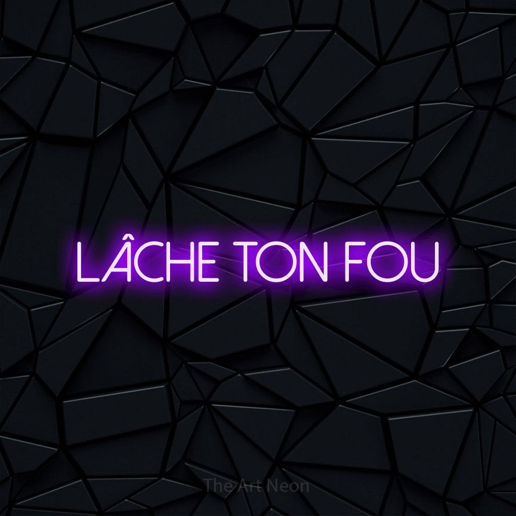 “Lâche ton fou” LED neon sign in purple, with thin sans-serif lettering, shown against a black polygonal surface.
