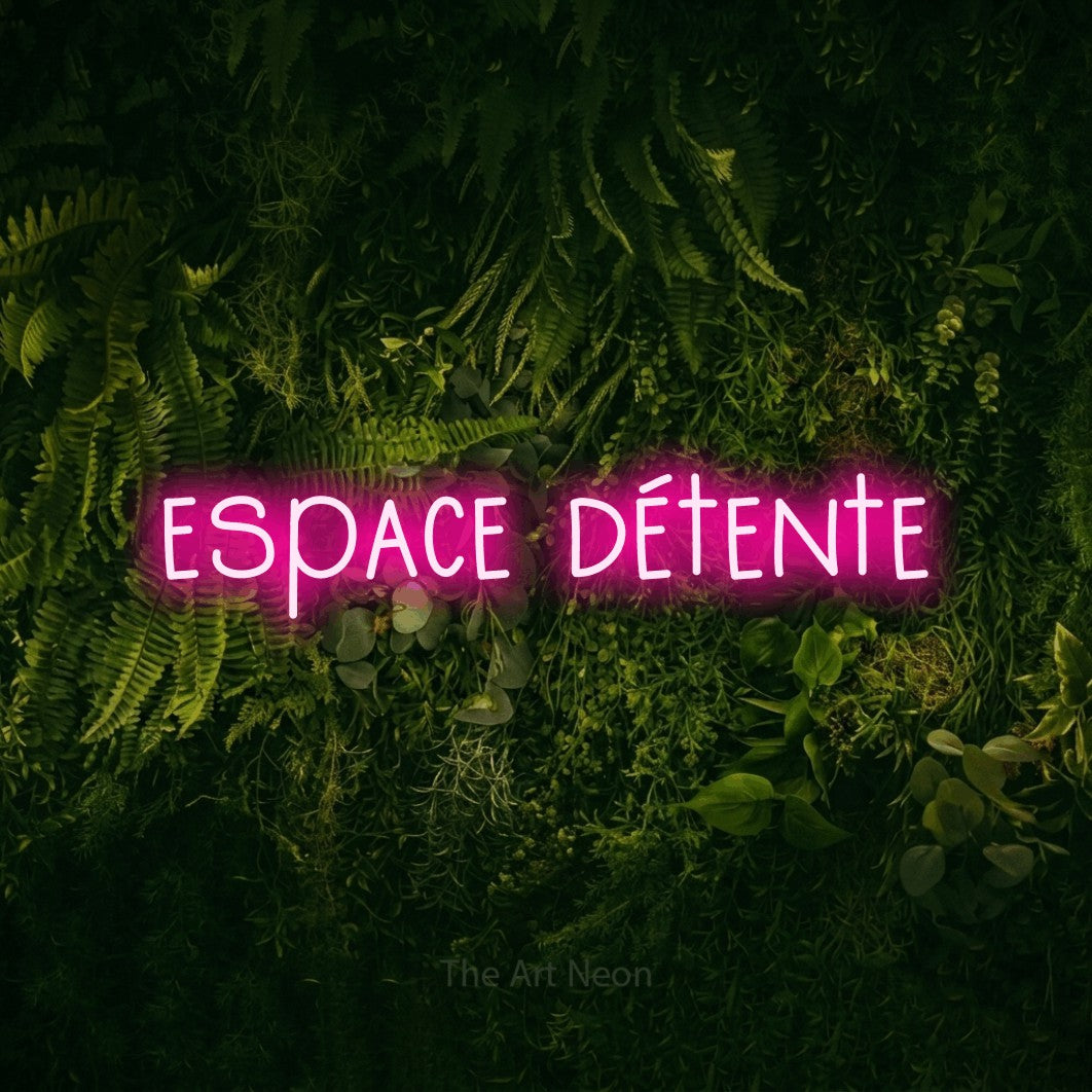 “Espace détente” LED neon sign in hot pink, with narrow hand-drawn lettering, shown against a dark moss and forest backdrop.