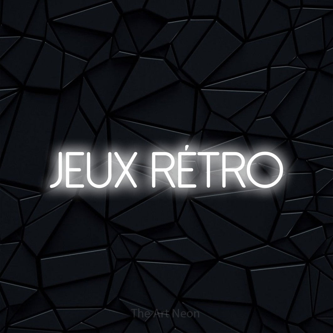 Aperçu d’une enseigne néon LED « Jeux rétro » en blanc froid, en lettres fines sans empattement, photographiée sur une surface polygonale noire, pour un espace de jeux vidéo.