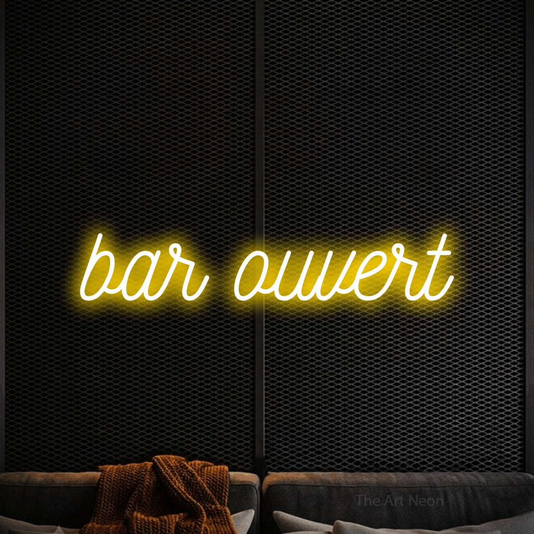 Enseigne néon LED « Bar ouvert » en jaune, en écriture cursive ornée, présentée dans un coin salon moderne aux tons noirs, pour un bar à la maison.