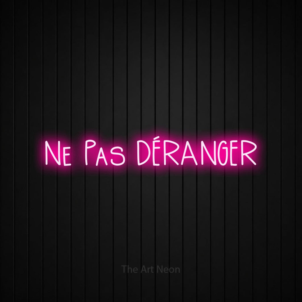 “Ne pas déranger” LED neon sign in hot pink, with narrow hand-drawn lettering, shown against black vertical wall slats.