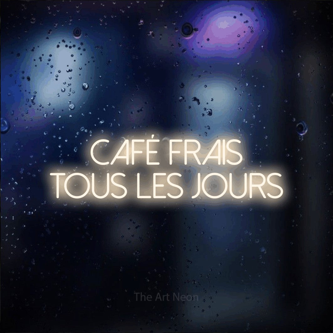 “Café frais tous les jours” LED neon sign in warm white, with thin sans-serif lettering across 2 lines, shown against glass with blue and purple reflections.