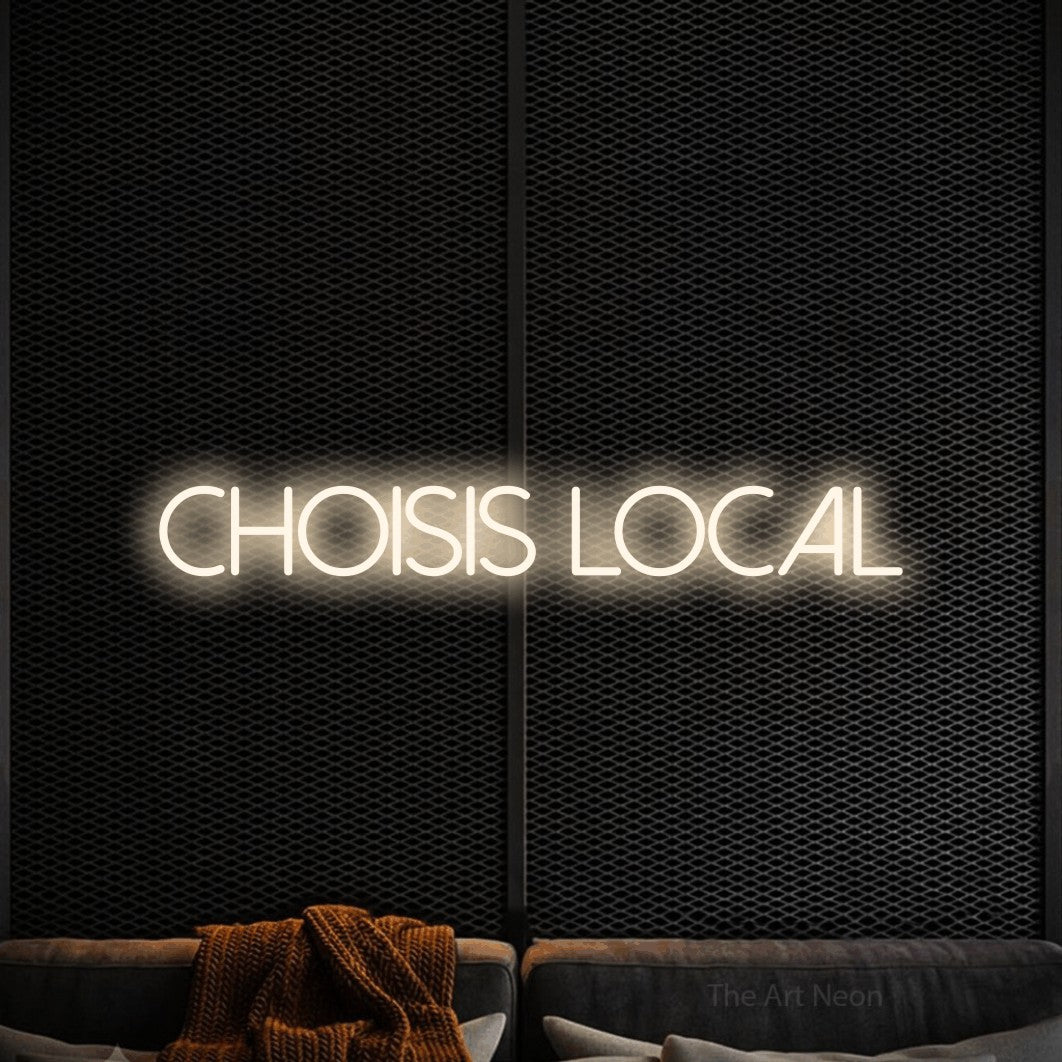 “Choisis local” LED neon sign in warm white, with thin sans-serif lettering, shown against a modern dark-toned seating area.