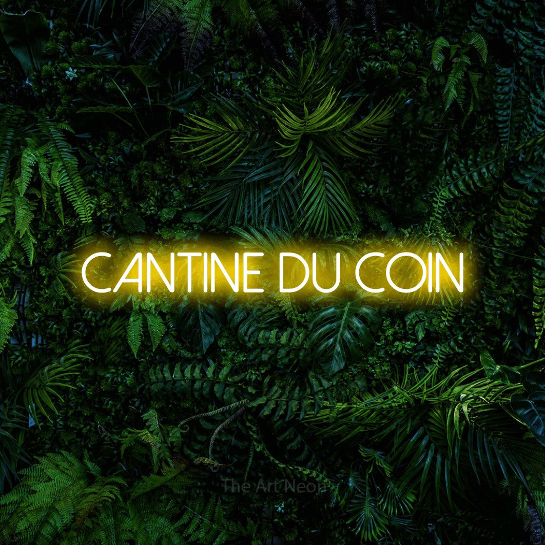 “Cantine du coin” LED neon sign in yellow, with thin sans-serif lettering, shown against dense tropical foliage.