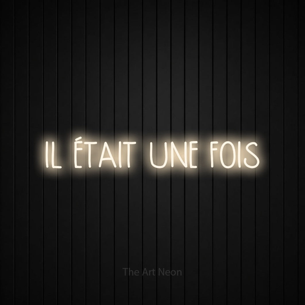 “Il était une fois” LED neon sign in warm white, with narrow hand-drawn lettering, shown against black vertical wall slats.