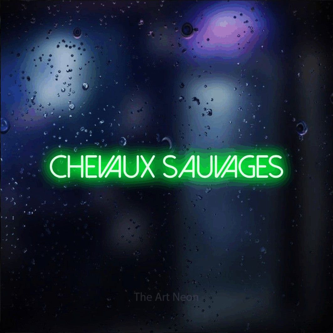 “Chevaux sauvages” LED neon sign in green, with thin sans-serif lettering, shown against glass with blue and purple reflections.