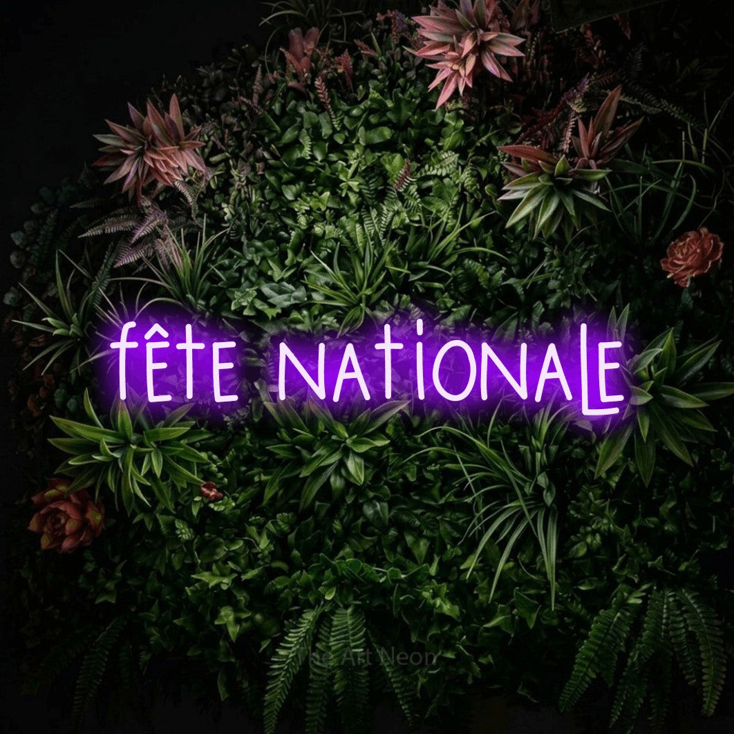“Fête nationale” LED neon sign in purple, with narrow hand-drawn lettering, shown against a flowering plant wall.