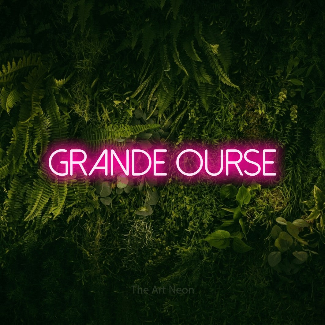 “Grande ourse” LED neon sign in hot pink, with thin sans-serif lettering, shown against a dark moss and forest backdrop.