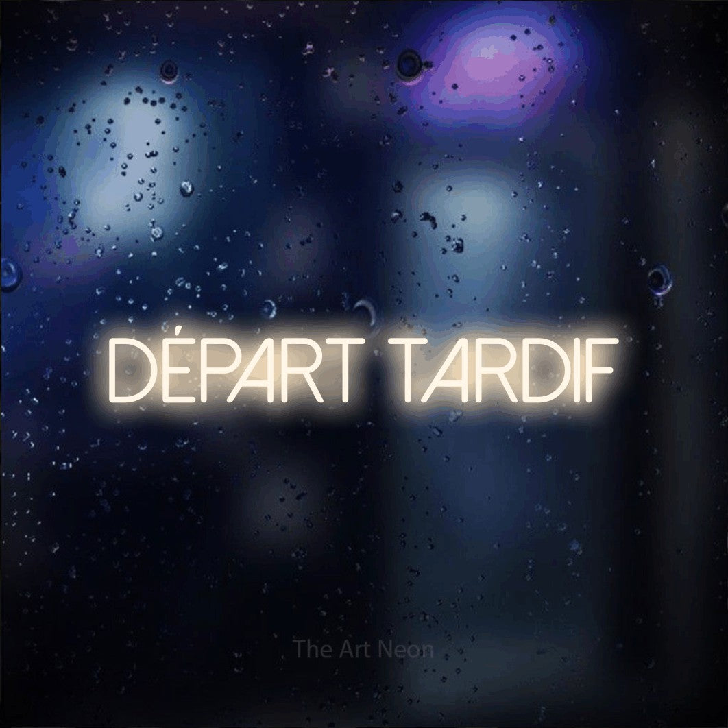 “Départ tardif” LED neon sign in warm white, with thin sans-serif lettering, shown against glass with blue and purple reflections.