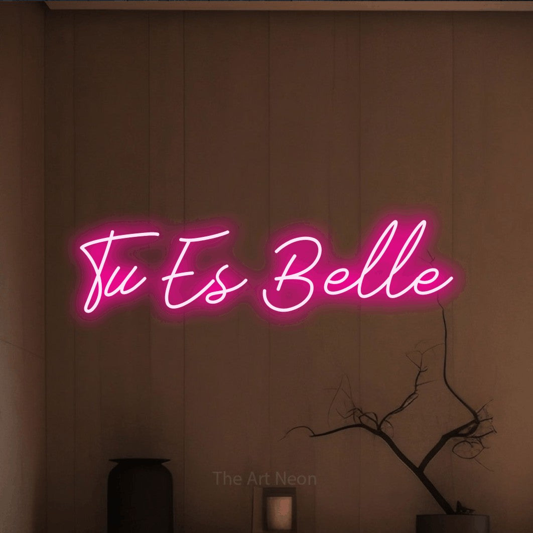 Enseigne néon LED « Tu es belle » en rose vif, en lettrage cursif, présentée dans un intérieur épuré aux tons terre, pour un salon de beauté.