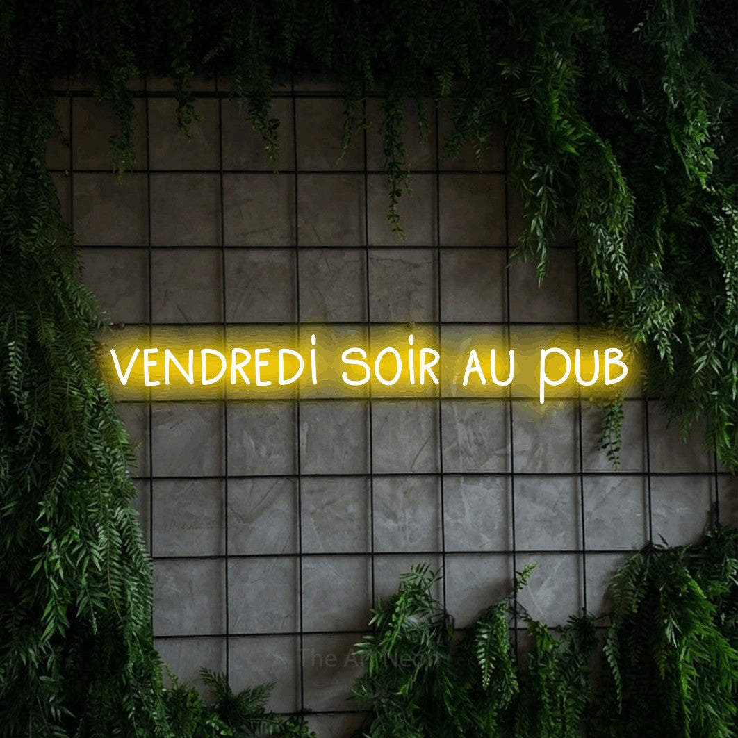 “Vendredi soir au pub” LED neon sign in yellow, with narrow hand-drawn lettering, shown against an ivy-covered concrete grid.