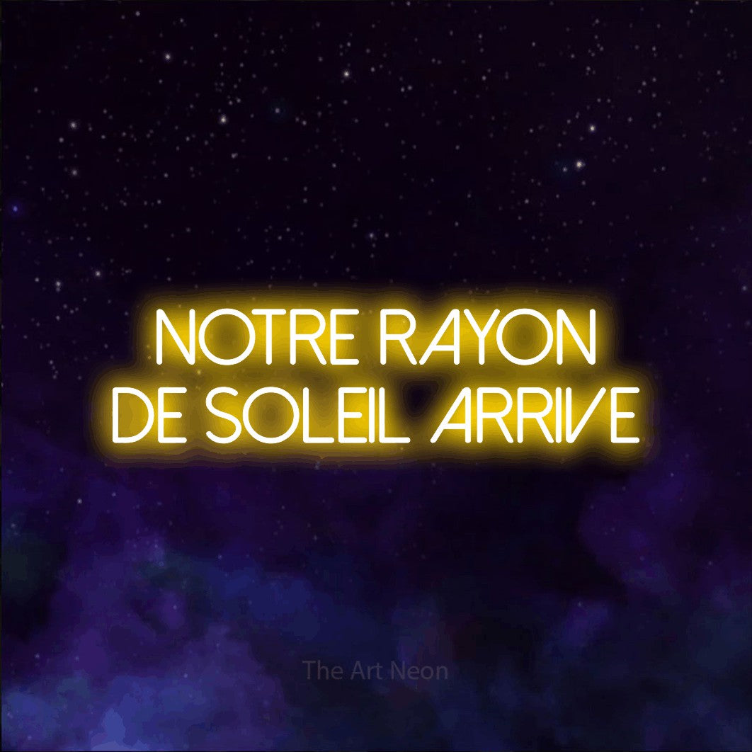Enseigne néon LED « Notre rayon de soleil arrive » sur deux lignes en jaune, en lettres fines sans empattement, présentée sur une texture de galaxie violette, pour une fête prénatale.