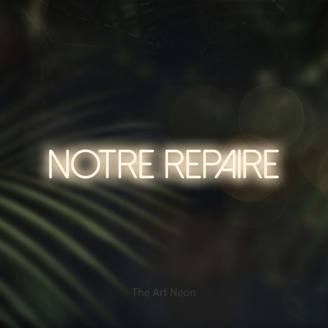 “Notre repaire” LED neon sign in warm white, with thin sans-serif lettering, shown against a blurred palm and bokeh-light backdrop.