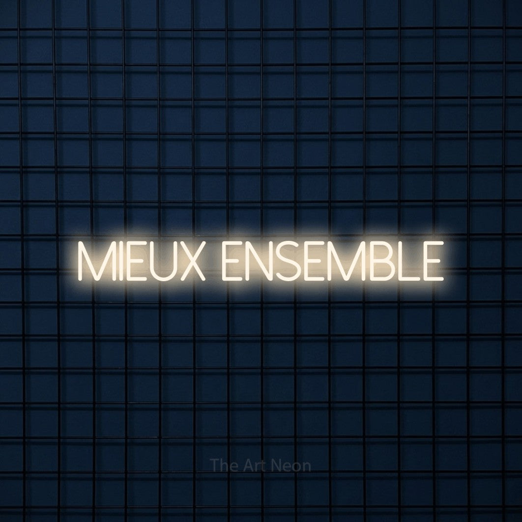 “Mieux ensemble” LED neon sign in warm white, with thin sans-serif lettering, shown against a dark blue grid.