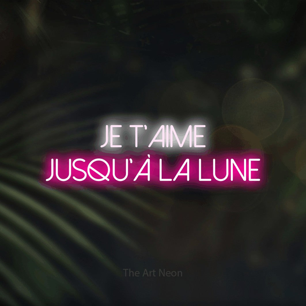 “Je t'aime jusqu'à la lune” LED neon sign in cool white on the upper line and hot pink on the lower line, with thin sans-serif lettering across 2 lines, shown against a blurred palm and bokeh-light backdrop.