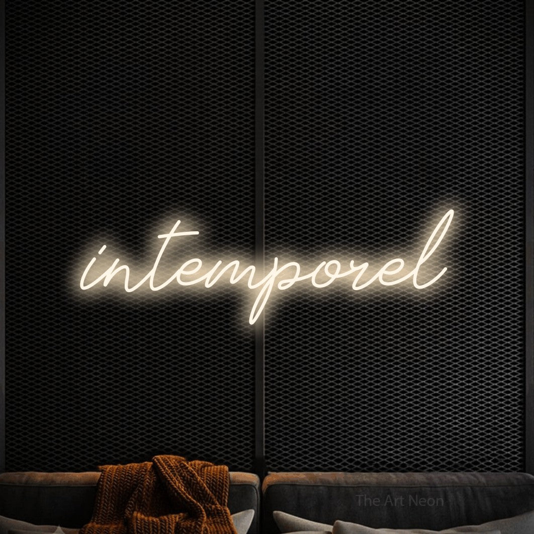 “Intemporel” LED neon sign in warm white, with cursive lettering, shown against a modern dark-toned seating area.
