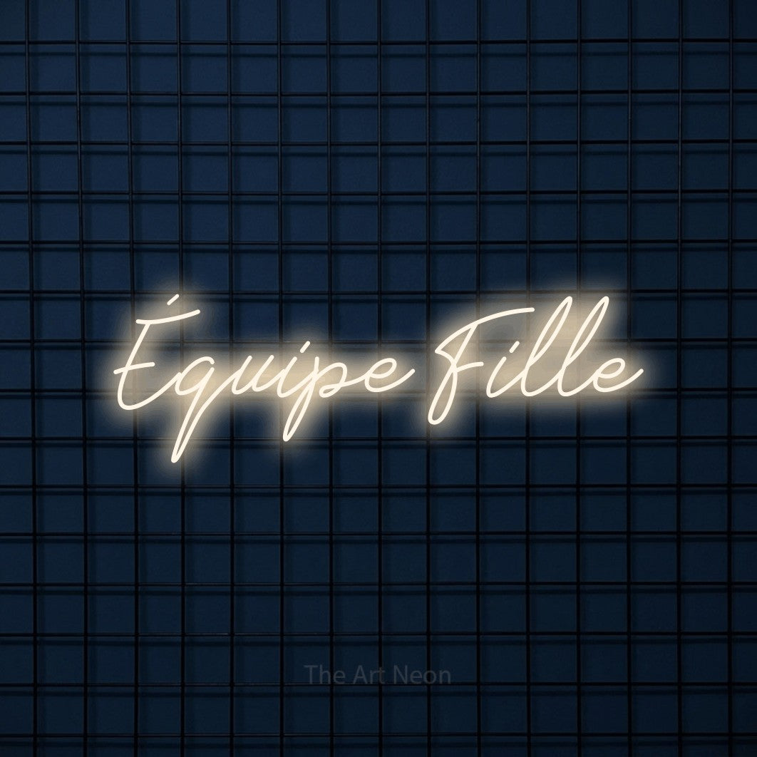 “Équipe fille” LED neon sign in warm white, with cursive lettering, shown against a dark blue grid.