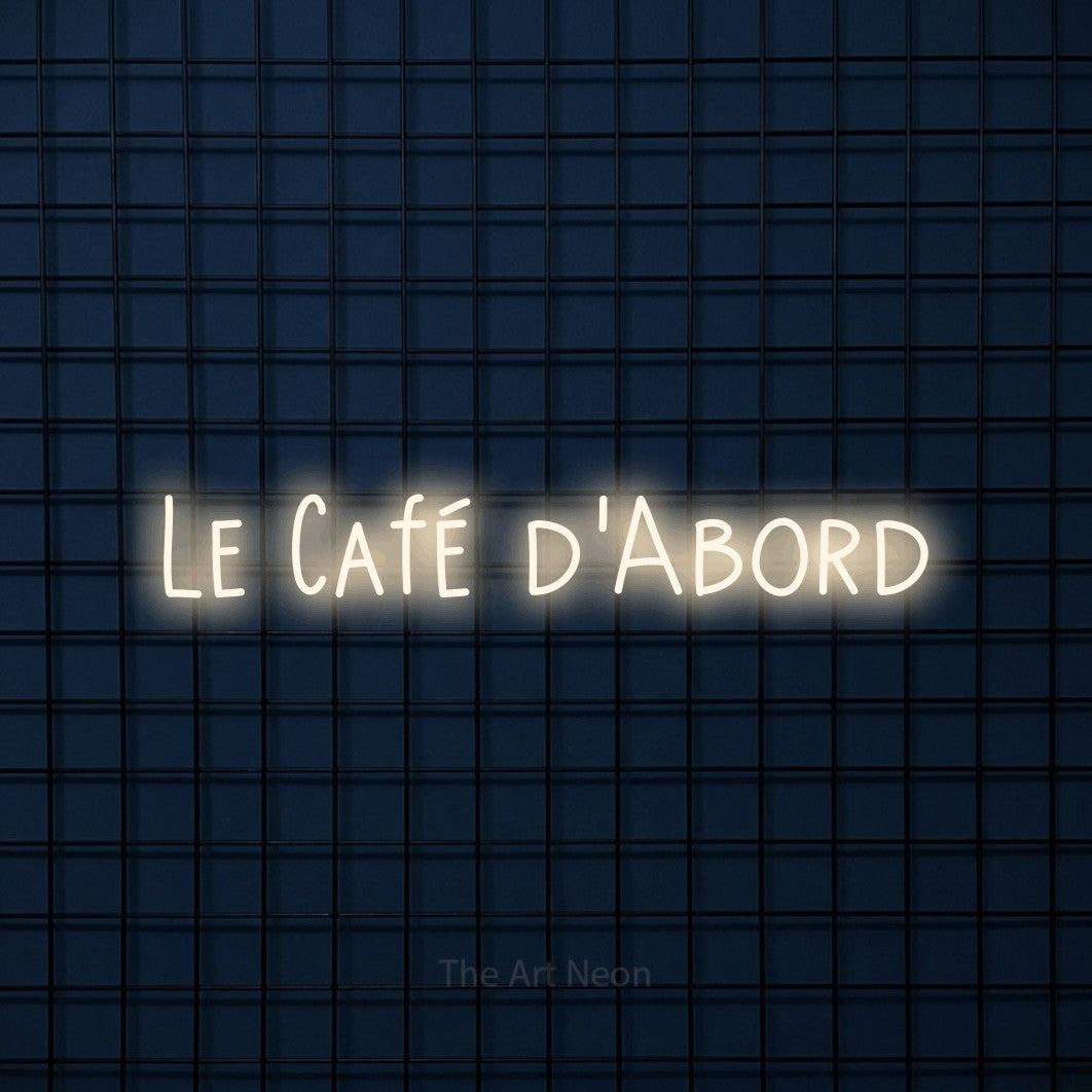 Lettrage en néon LED « Le café d'abord » en blanc chaud, en lettres étroites dessinées à la main, présenté sur une grille bleu foncé, pour un café.
