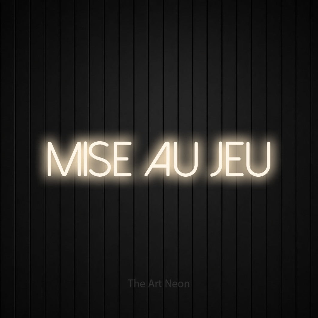 Composition en néon LED « Mise au jeu » en blanc chaud, en lettres fines sans empattement, mise en valeur sur un mur de lattes verticales noires, pour un décor de hockey.