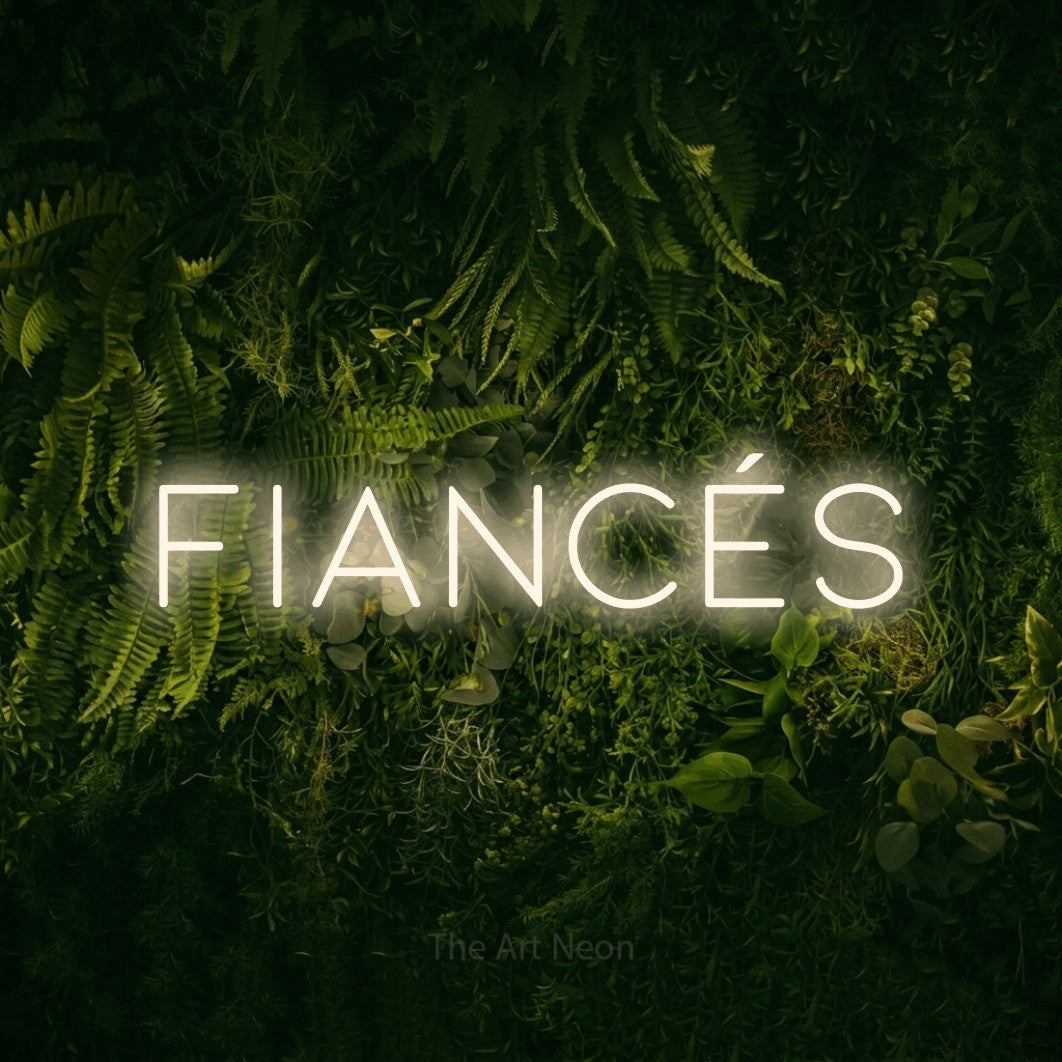 “Fiancés” LED neon sign in warm white, with thin, widely spaced lettering, shown against a dark moss and forest backdrop.