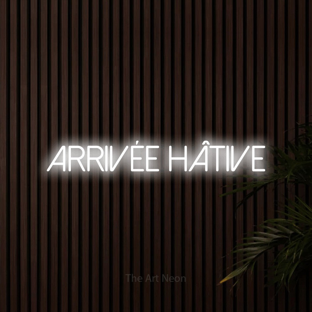 “Arrivée hâtive” LED neon sign in cool white, with thin sans-serif lettering, shown against dark wooden wall slats.