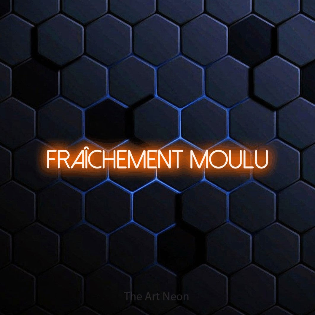 Décoration murale en néon LED « Fraîchement moulu » en orange, en lettres fines sans empattement, installée sur un motif alvéolé bleu foncé, pour un café.