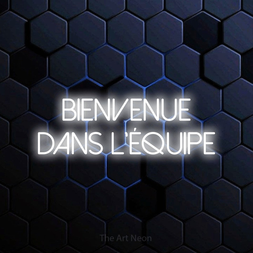 “Bienvenue dans l'équipe” LED neon sign in cool white, with thin sans-serif lettering across 2 lines, shown against a dark blue honeycomb pattern.