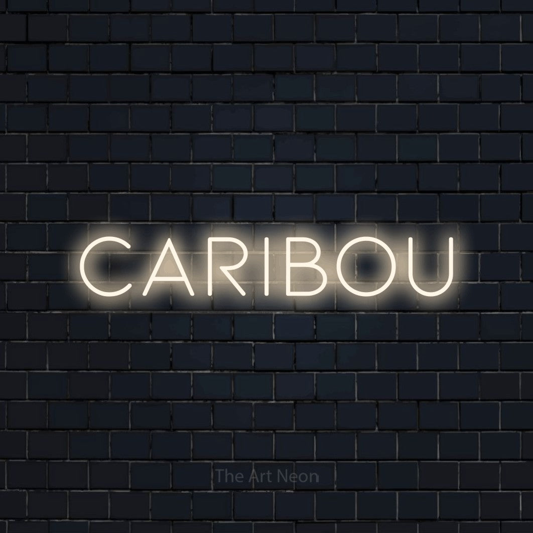“Caribou” LED neon sign in warm white, with thin, widely spaced lettering, shown against a dark navy brick wall.