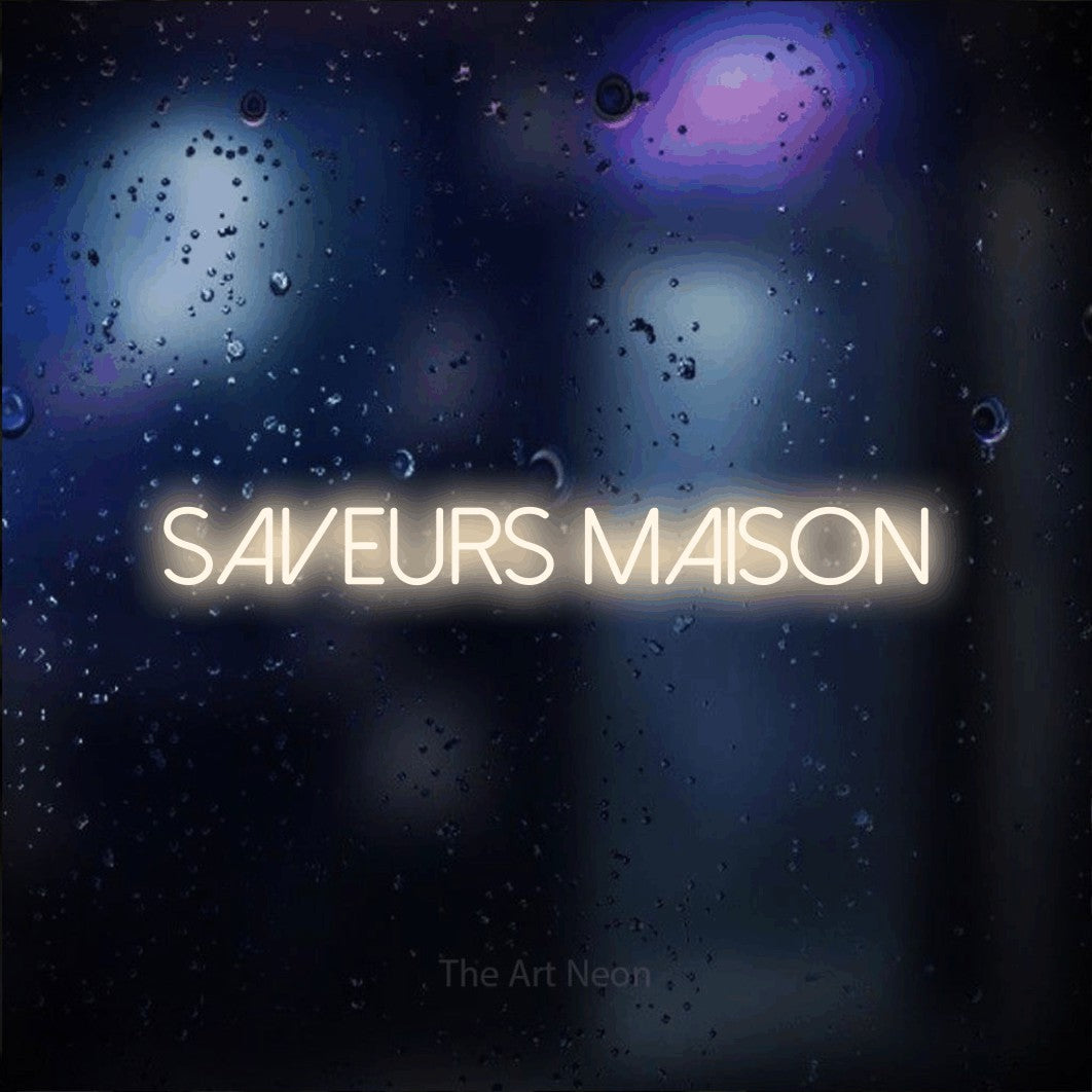 “Saveurs maison” LED neon sign in warm white, with thin sans-serif lettering, shown against glass with blue and purple reflections.
