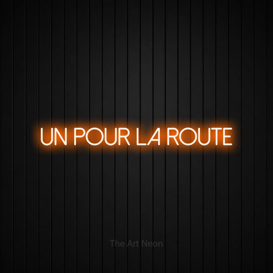 Néon LED « Un pour la route » en orange, en lettres fines sans empattement, mis en scène sur un mur de lattes verticales noires, pour un bar à la maison.