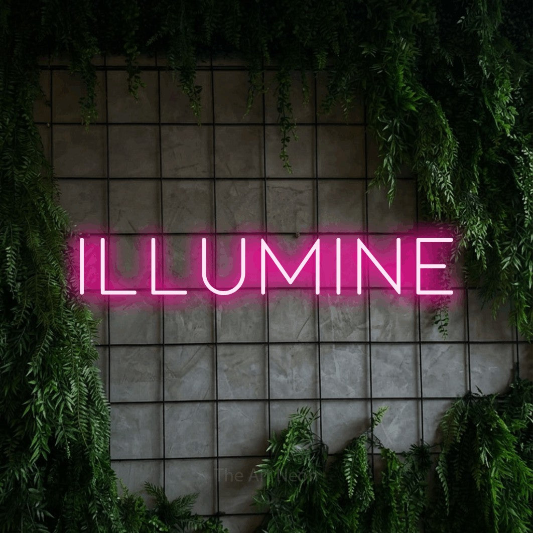 “Illumine” LED neon sign in hot pink, with thin, widely spaced lettering, shown against an ivy-covered concrete grid.