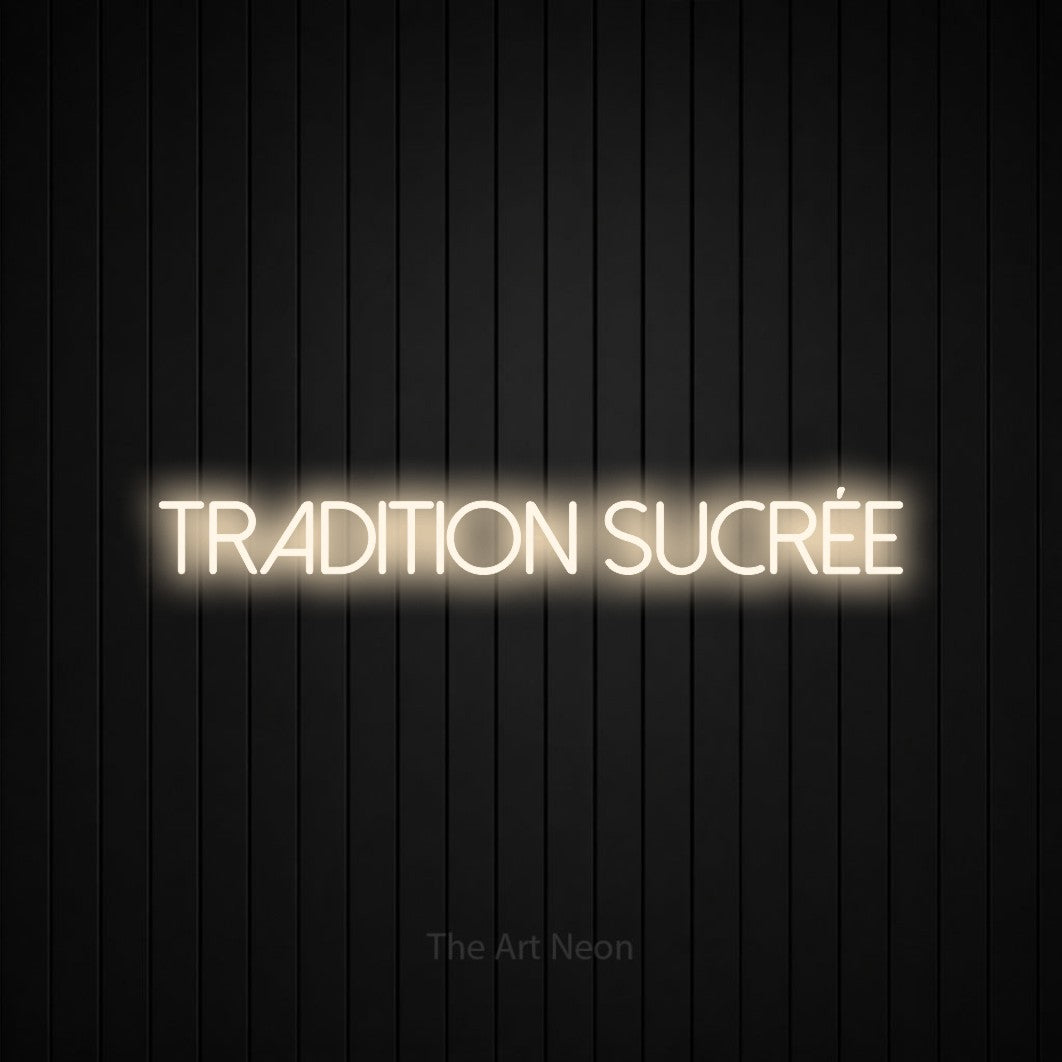 “Tradition sucrée” LED neon sign in warm white, with thin sans-serif lettering, shown against black vertical wall slats.