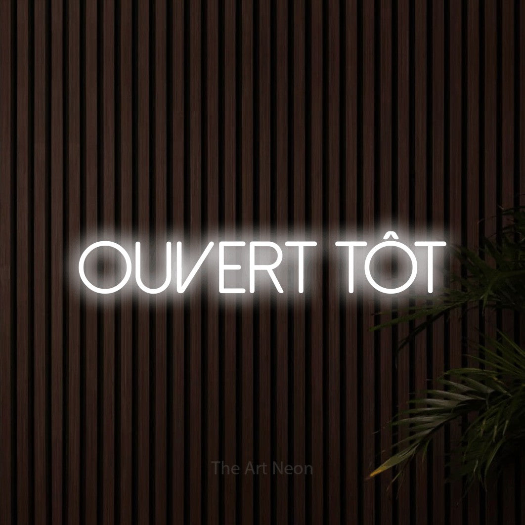 Lettrage en néon LED « Ouvert tôt » en blanc froid, en lettres fines sans empattement, présenté sur un mur de lattes en bois foncé, pour un café.