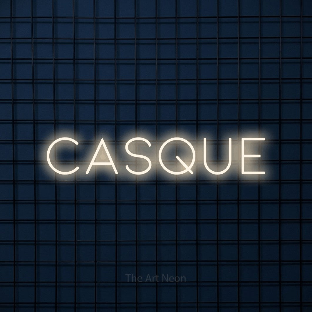 Composition en néon LED « Casque » en blanc chaud, en lettres fines et espacées, mise en valeur sur une grille bleu foncé, pour un décor de hockey.