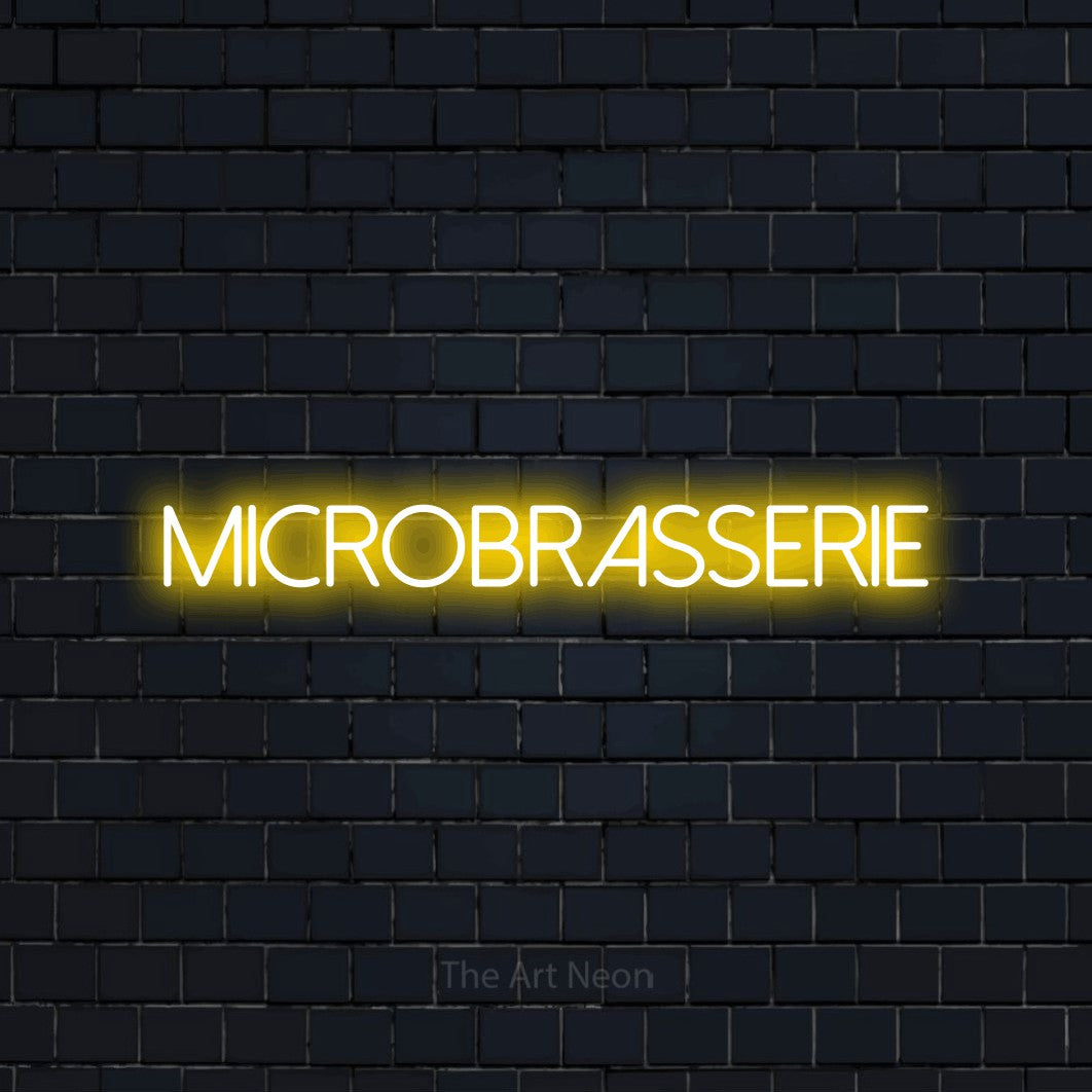 “Microbrasserie” LED neon sign in yellow, with thin sans-serif lettering, shown against a dark navy brick wall.