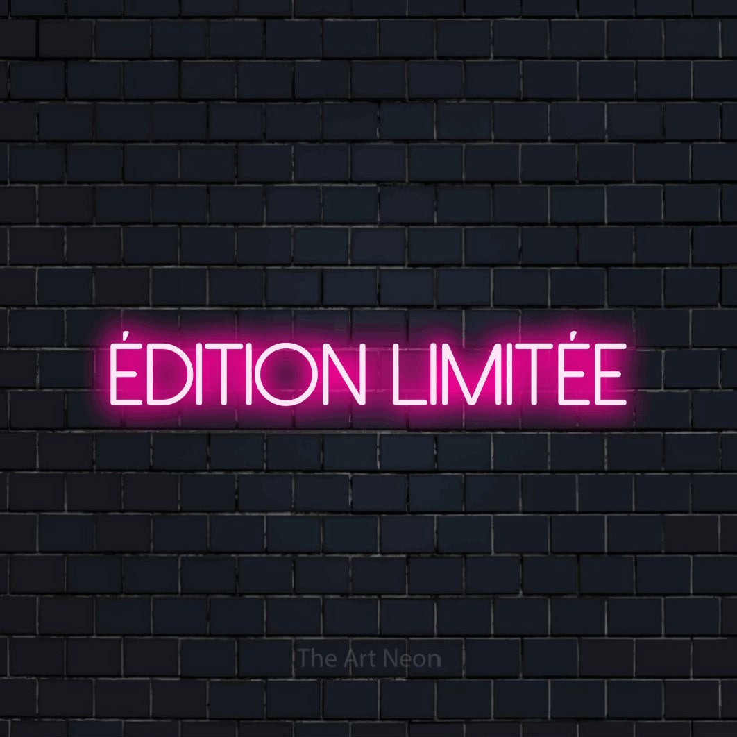 “Édition limitée” LED neon sign in hot pink, with thin sans-serif lettering, shown against a dark navy brick wall.