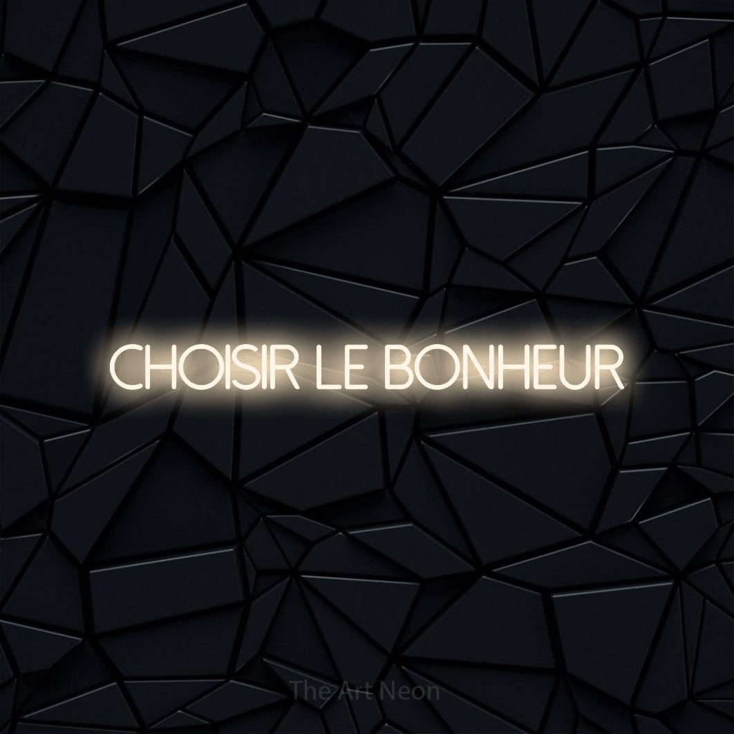 “Choisir le bonheur” LED neon sign in warm white, with thin sans-serif lettering, shown against a black polygonal surface.