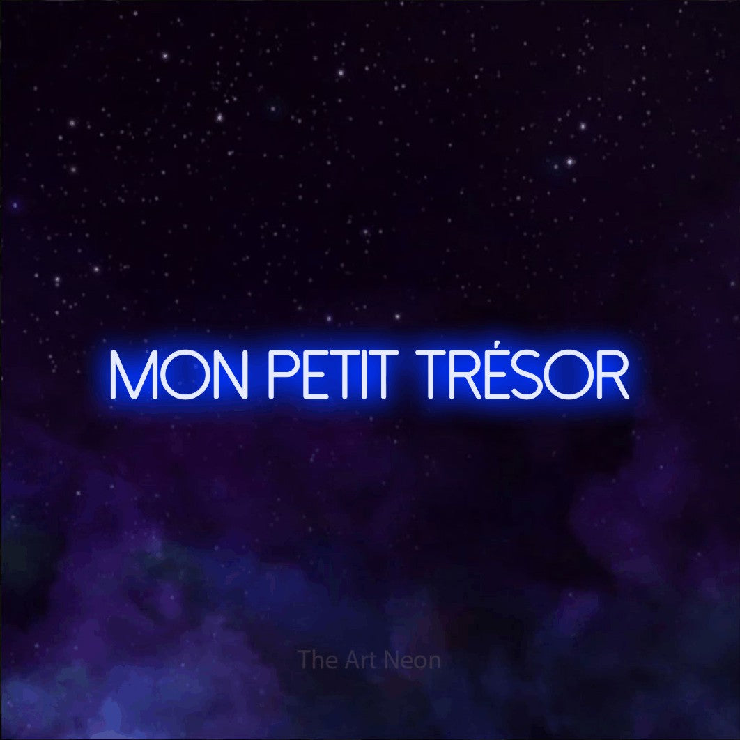 “Mon petit trésor” LED neon sign in blue, with thin sans-serif lettering, shown against a purple galaxy backdrop.