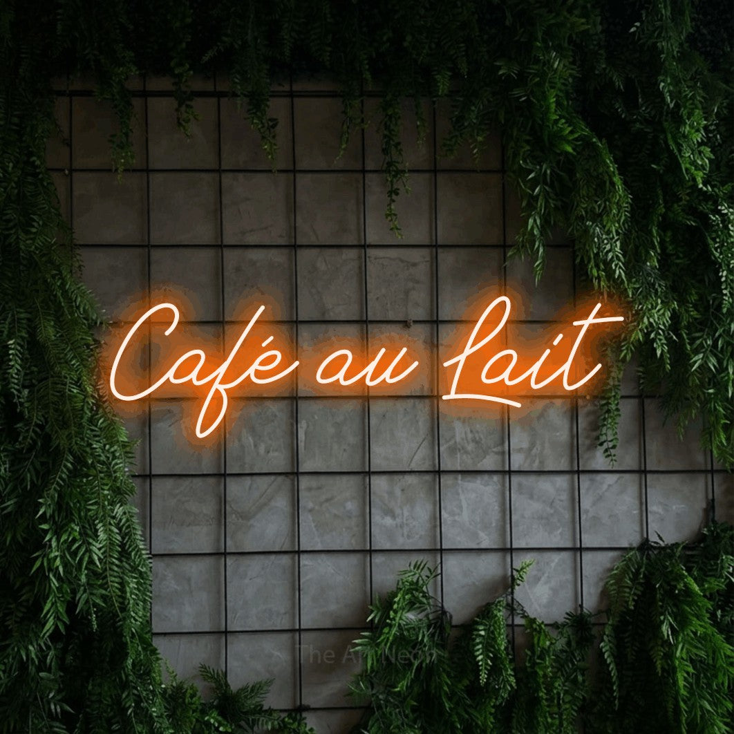 “Café au lait” LED neon sign in orange, with cursive lettering, shown against an ivy-covered concrete grid.